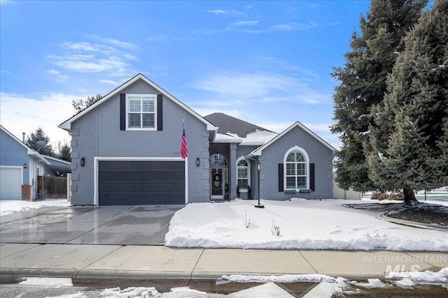 view of front of home with an attached garage, concrete driveway, and stucco siding