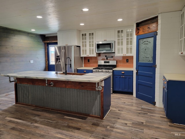 kitchen with a spacious island, white cabinetry, stainless steel appliances, and dark hardwood / wood-style floors