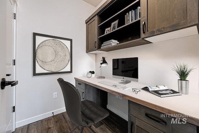 office area featuring dark wood-type flooring, baseboards, and built in desk