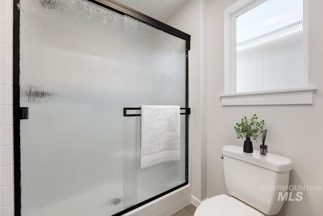 bathroom with toilet and a shower stall