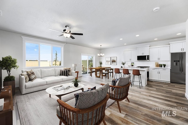 living room with wood finished floors, a chandelier, recessed lighting, and ceiling fan