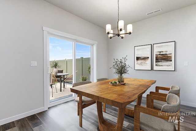 dining room featuring a chandelier, dark wood-style floors, and baseboards