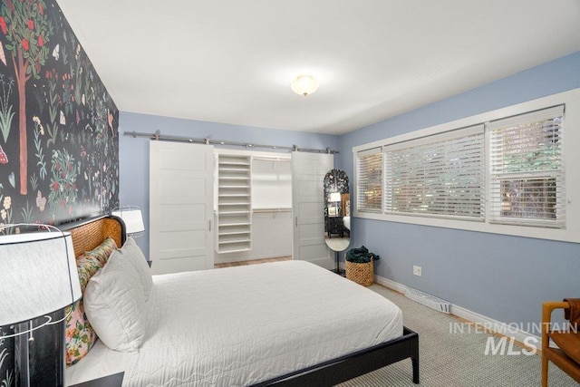 606 S Ridge Rd, Moscow, ID 83843 - carpeted bedroom featuring a barn door, baseboards, and a walk in closet