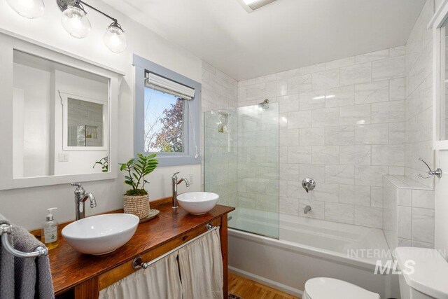 606 S Ridge Rd, Moscow, ID 83843 - full bathroom featuring toilet, wood finished floors, shower / bath combination with glass door, and double vanity