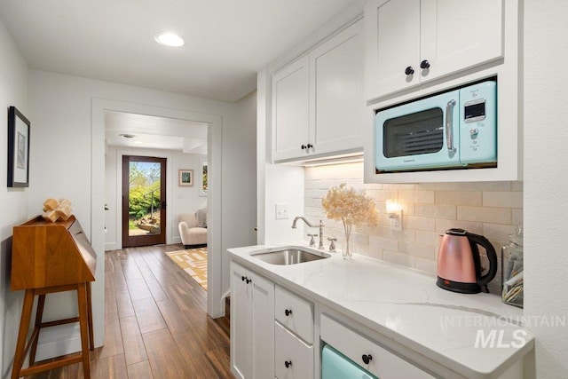 606 S Ridge Rd, Moscow, ID 83843 - kitchen with white microwave, a sink, decorative backsplash, white cabinets, and recessed lighting
