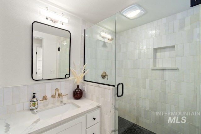 606 S Ridge Rd, Moscow, ID 83843 - bathroom featuring a stall shower, tile walls, vanity, and backsplash