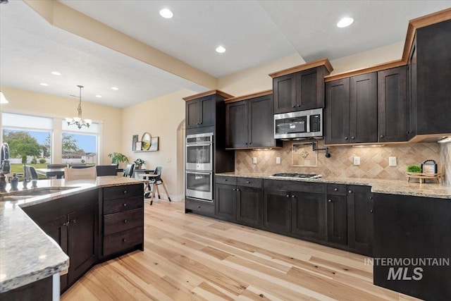 14942 Midway Rd, Nampa, ID 83651 - kitchen featuring stainless steel appliances, a sink, light wood finished floors, tasteful backsplash, and recessed lighting