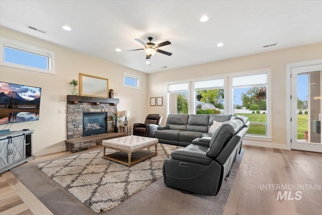 14942 Midway Rd, Nampa, ID 83651 - living area with wood finished floors, a stone fireplace, recessed lighting, baseboards, and a ceiling fan