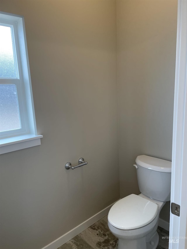 bathroom with toilet and baseboards