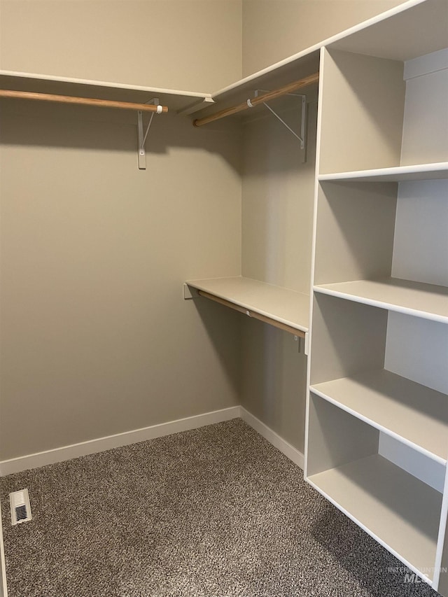 spacious closet with visible vents and dark carpet