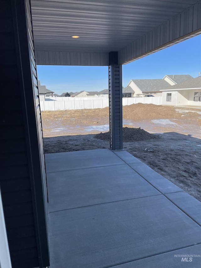 view of patio featuring a residential view and fence