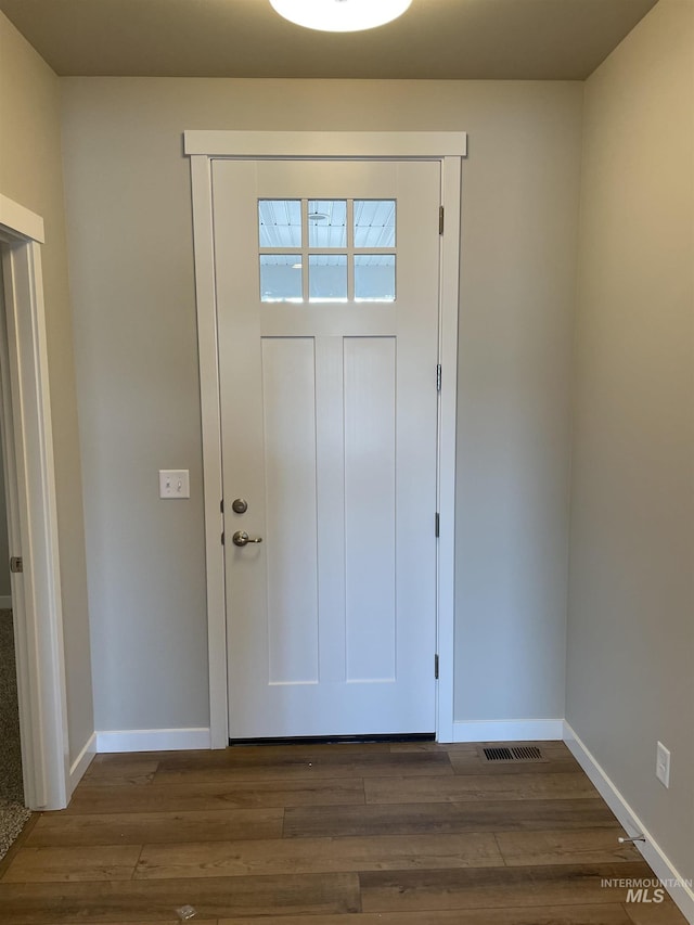 foyer entrance featuring baseboards and dark wood finished floors