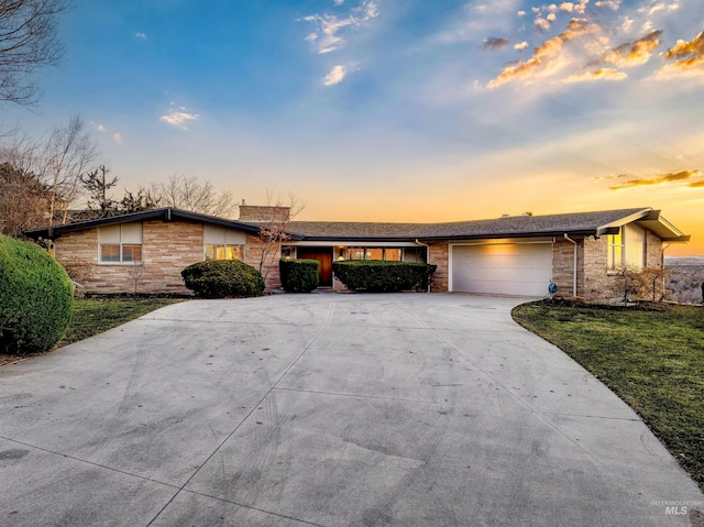 ranch-style home with a garage and a yard