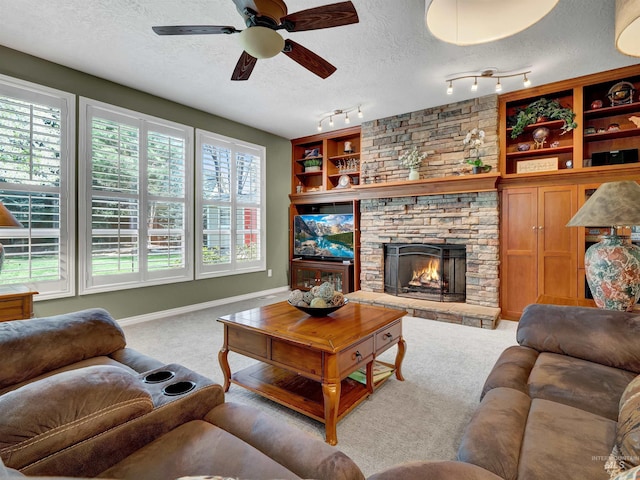 1546 N Dragonfly Ct, Eagle, ID 83616 - carpeted living room featuring baseboards, a ceiling fan, a textured ceiling, and a stone fireplace