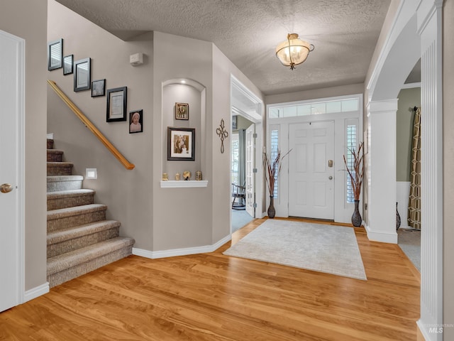 1546 N Dragonfly Ct, Eagle, ID 83616 - entrance foyer with stairs, arched walkways, a textured ceiling, and light wood finished floors