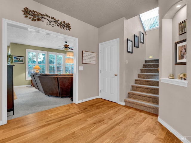 1546 N Dragonfly Ct, Eagle, ID 83616 - entrance foyer with light wood-type flooring, baseboards, stairway, a ceiling fan, and a textured ceiling