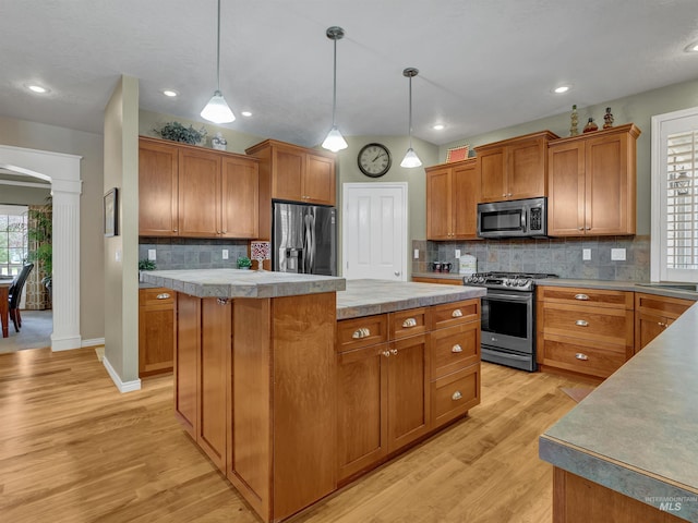 1546 N Dragonfly Ct, Eagle, ID 83616 - kitchen featuring brown cabinetry, light wood finished floors, a kitchen island, and stainless steel appliances