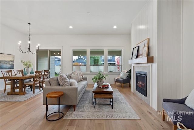 11270 S Saylis Way, Kuna, ID 83634 - living area with light wood finished floors, a glass covered fireplace, a chandelier, and recessed lighting