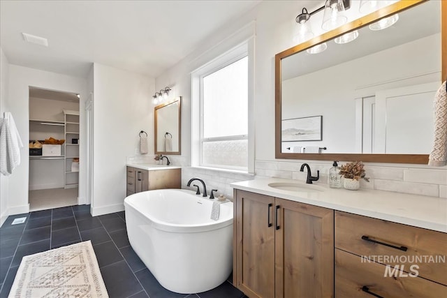 11270 S Saylis Way, Kuna, ID 83634 - bathroom featuring two vanities, tile patterned floors, a freestanding tub, and a spacious closet
