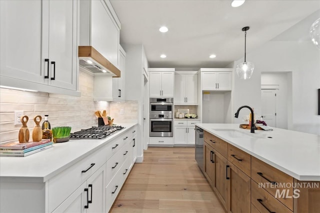 11270 S Saylis Way, Kuna, ID 83634 - kitchen featuring appliances with stainless steel finishes, premium range hood, light wood finished floors, white cabinetry, and recessed lighting