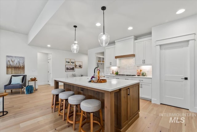 11270 S Saylis Way, Kuna, ID 83634 - kitchen featuring stainless steel gas stovetop, backsplash, light wood finished floors, white cabinets, and light countertops