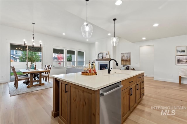 11270 S Saylis Way, Kuna, ID 83634 - kitchen with stainless steel dishwasher, brown cabinets, light wood-style flooring, recessed lighting, and a kitchen island with sink