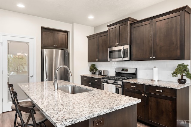 3065 E Ionia Ct, Meridian, ID 83642 - kitchen with appliances with stainless steel finishes, a sink, an island with sink, a kitchen breakfast bar, and dark brown cabinets