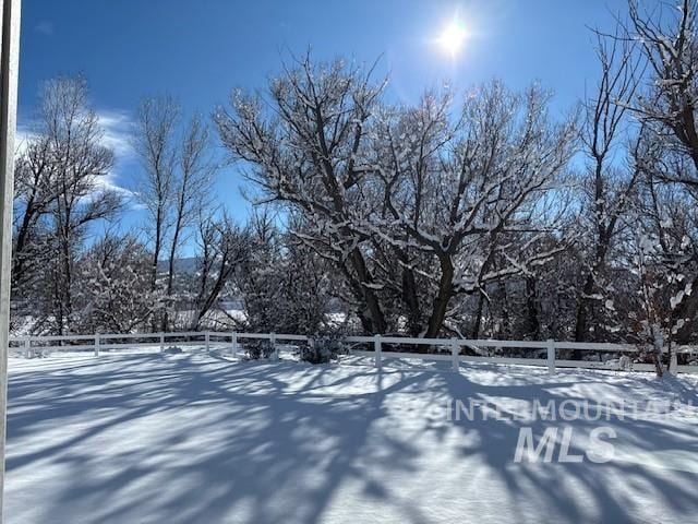 snowy yard featuring fence
