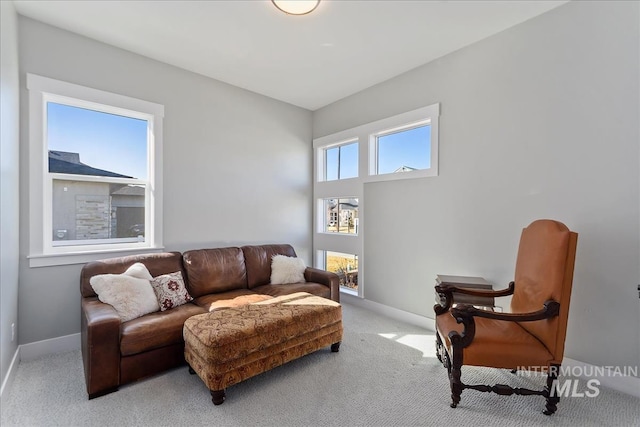 living area with light carpet and baseboards
