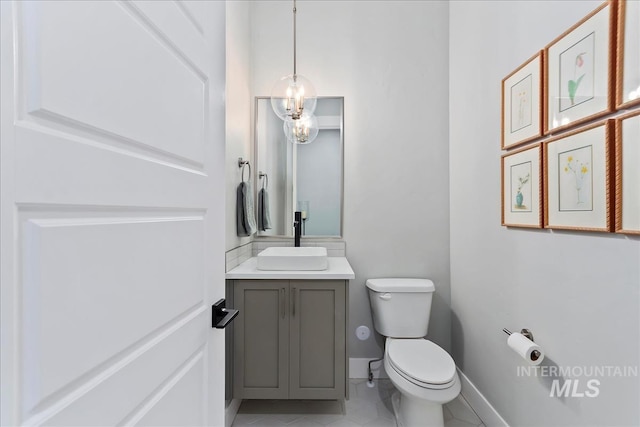 bathroom featuring vanity, toilet, and baseboards