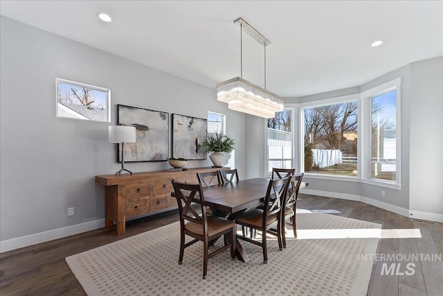 dining area with baseboards, wood finished floors, and recessed lighting