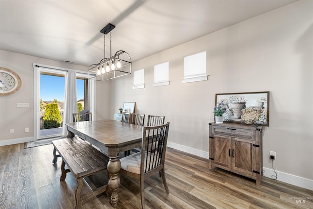 3056 E Columbus River Ct, Nampa, ID 83686 - dining space featuring baseboards, a notable chandelier, wood finished floors, and a wealth of natural light