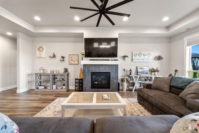 3056 E Columbus River Ct, Nampa, ID 83686 - living area with ceiling fan, wood finished floors, a tile fireplace, baseboards, and a raised ceiling