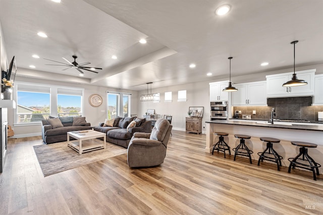 3056 E Columbus River Ct, Nampa, ID 83686 - living room with baseboards, light wood finished floors, a tray ceiling, and recessed lighting