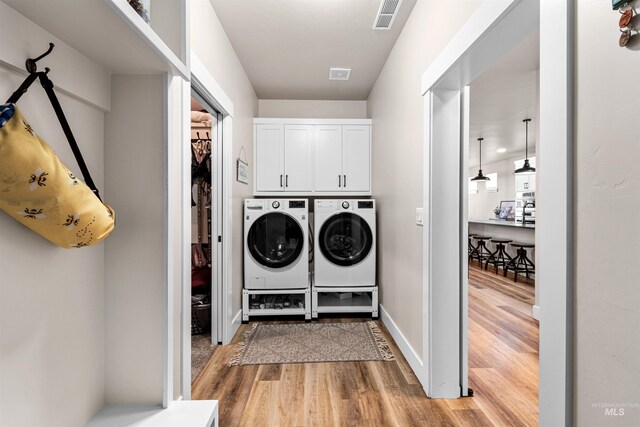3056 E Columbus River Ct, Nampa, ID 83686 - clothes washing area with visible vents, cabinet space, independent washer and dryer, and wood finished floors