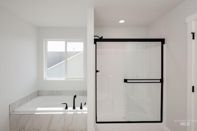 bathroom with a shower stall and a bath