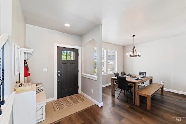 foyer entrance featuring an inviting chandelier and dark wood-type flooring