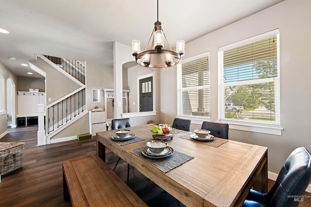 dining room with dark wood-type flooring and an inviting chandelier