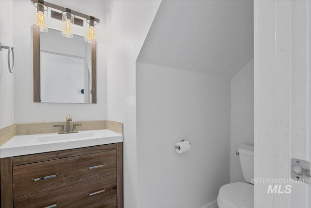 2702 N Camden Pl, Boise, ID 83704 - bathroom featuring tasteful backsplash, vanity, baseboards, toilet, and lofted ceiling