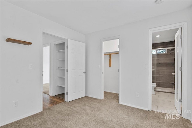 2702 N Camden Pl, Boise, ID 83704 - unfurnished bedroom with baseboards, carpet flooring, a closet, and a walk in closet