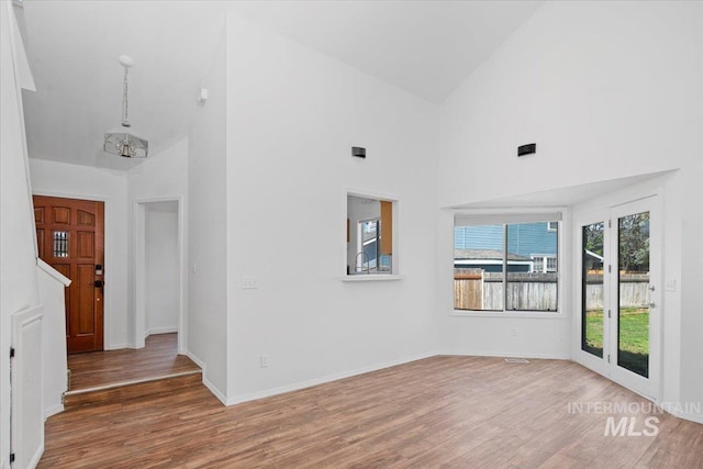 2702 N Camden Pl, Boise, ID 83704 - unfurnished room with baseboards, wood finished floors, high vaulted ceiling, and an inviting chandelier