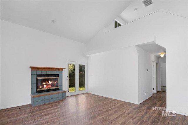 2702 N Camden Pl, Boise, ID 83704 - unfurnished living room featuring high vaulted ceiling, wood finished floors, a tile fireplace, baseboards, and visible vents