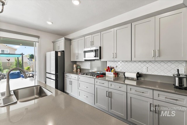 11211 Sopris Loop, Caldwell, ID 83605 - kitchen featuring appliances with stainless steel finishes, a sink, tasteful backsplash, gray cabinetry, and recessed lighting