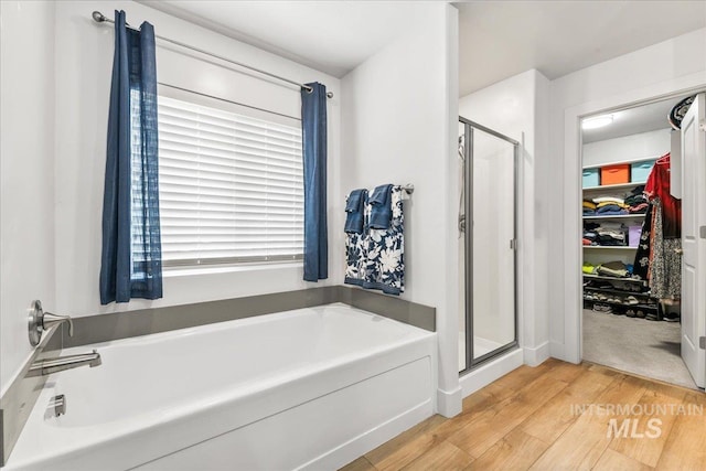 11211 Sopris Loop, Caldwell, ID 83605 - full bath with wood finished floors, a shower stall, a spacious closet, and a garden tub
