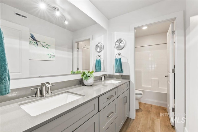 11211 Sopris Loop, Caldwell, ID 83605 - bathroom with wood finished floors, toilet, double vanity, and tub / shower combination