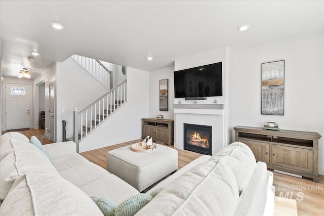 11211 Sopris Loop, Caldwell, ID 83605 - living area featuring stairway, a glass covered fireplace, light wood-type flooring, and recessed lighting