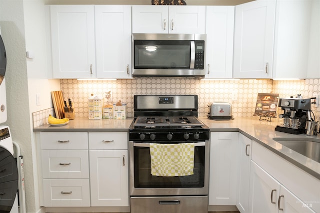 kitchen with backsplash, stainless steel appliances, and white cabinets