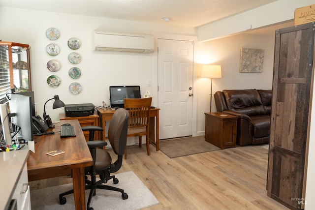 office area with a wall mounted air conditioner and light hardwood / wood-style flooring