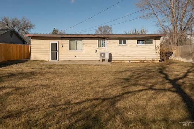 rear view of property featuring a lawn and ac unit