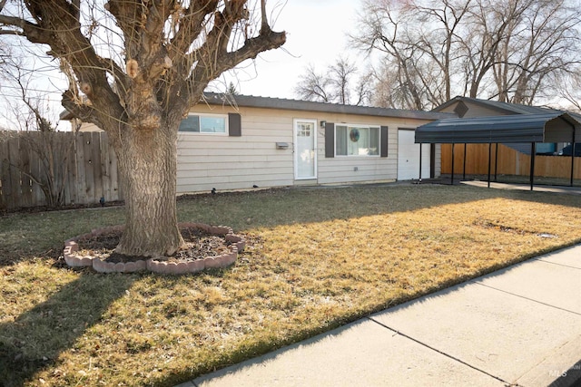 ranch-style home featuring a carport and a front lawn